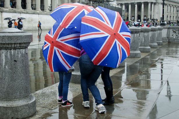 Tourists-seek-shelter-from-the-rain-in-Trafalgar-Square